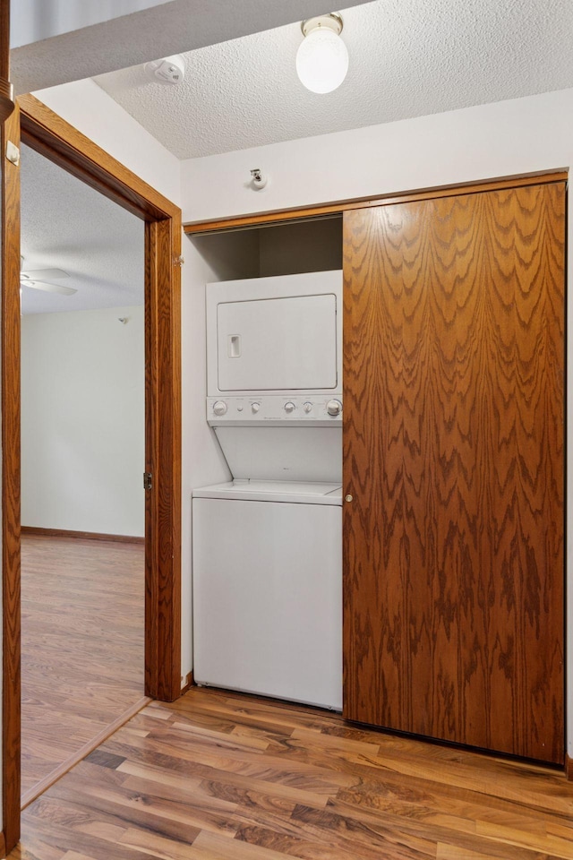 1225 Ferndale St N Unit B16, Maplewood, MN 55119 - washroom featuring estacked washer and dryer, wood finished floors, and a textured ceiling