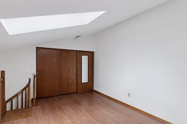 1225 Ferndale St N Unit B16, Maplewood, MN 55119 - unfurnished bedroom with a skylight, lofted ceiling, light wood-style flooring, and baseboards