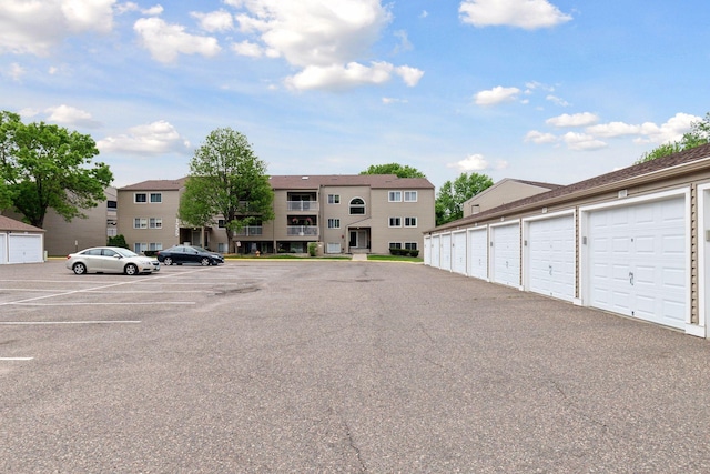 1225 Ferndale St N Unit B16, Maplewood, MN 55119 - uncovered parking lot featuring community garages and a residential view