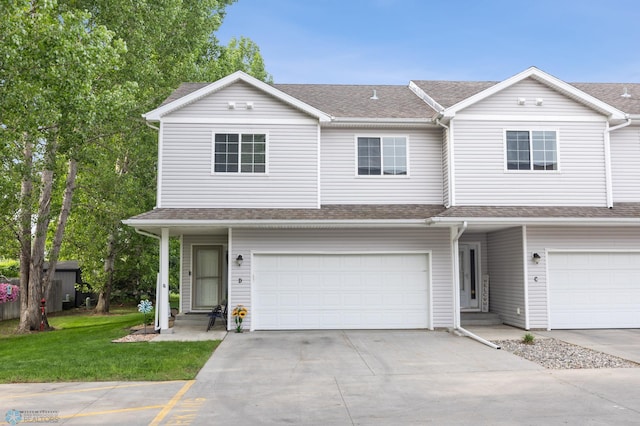 5512 Bishops Blvd S Unit D, Fargo, ND 58104 - townhome / multi-family property featuring an attached garage, concrete driveway, a front yard, and a shingled roof