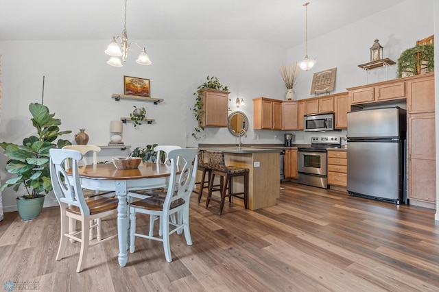 5512 Bishops Blvd S Unit D, Fargo, ND 58104 - dining space with dark wood-style floors, high vaulted ceiling, and a chandelier