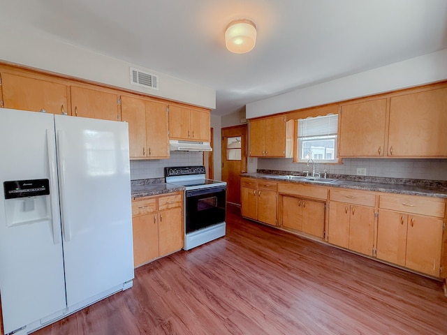 938 Selby Ave, Saint Paul Park, MN 55071 - kitchen with white fridge with ice dispenser, electric range oven, under cabinet range hood, dark countertops, and backsplash