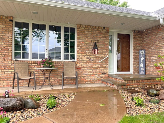 1715 Hansen Dr SW, Willmar, MN 56201 - property entrance with brick siding, a shingled roof, and a porch