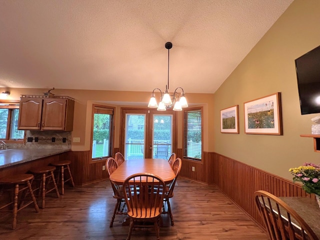 1715 Hansen Dr SW, Willmar, MN 56201 - dining area featuring a wainscoted wall, light wood finished floors, wooden walls, healthy amount of natural light, and a textured ceiling