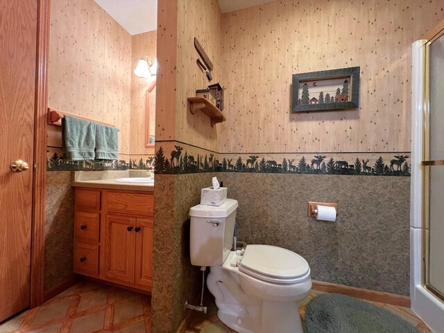 1715 Hansen Dr SW, Willmar, MN 56201 - bathroom with wallpapered walls, a shower with shower door, toilet, and vanity