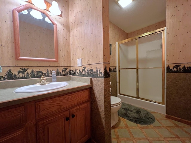 1715 Hansen Dr SW, Willmar, MN 56201 - full bathroom featuring wallpapered walls, a shower stall, vanity, tile patterned floors, and toilet