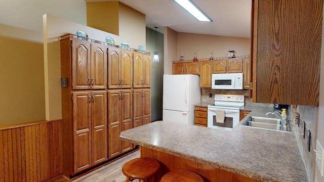 1715 Hansen Dr SW, Willmar, MN 56201 - kitchen with white appliances, a peninsula, tasteful backsplash, light wood-style flooring, and brown cabinets