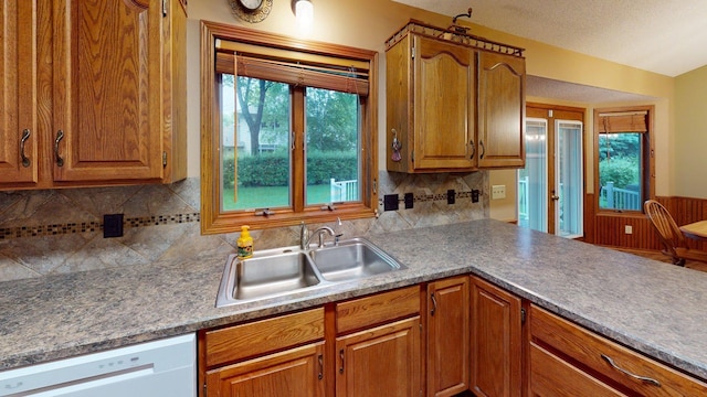 1715 Hansen Dr SW, Willmar, MN 56201 - kitchen featuring dishwasher, brown cabinetry, decorative backsplash, and a peninsula