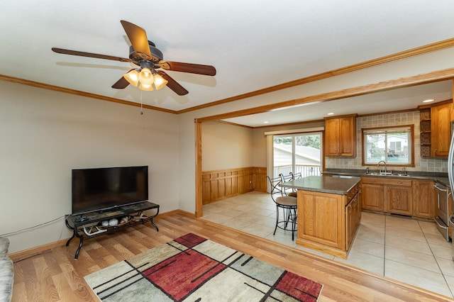 222 6th Ave NW, Byron, MN 55920 - kitchen with a sink, light wood-style flooring, a center island, wainscoting, and brown cabinets
