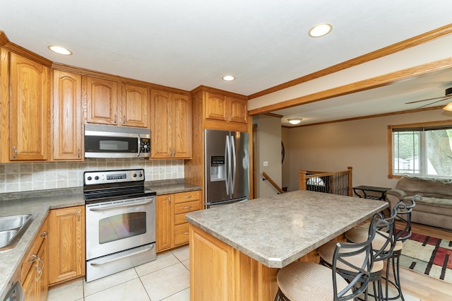 222 6th Ave NW, Byron, MN 55920 - kitchen with stainless steel appliances, a kitchen bar, open floor plan, crown molding, and recessed lighting