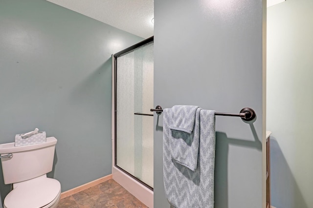 22669 128th Ave N, Rogers, MN 55374 - bathroom featuring a shower stall, toilet, baseboards, and a textured ceiling