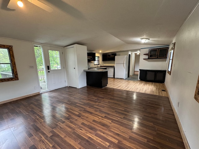 57230 351st St, Grove City, MN 56243 - unfurnished living room with a textured ceiling, lofted ceiling, wood finished floors, baseboards, and ceiling fan