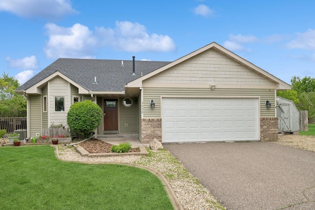 5430 Teal St, Big Lake, MN 55309 - view of front of home featuring brick siding, asphalt driveway, a garage, a front lawn, and roof with shingles