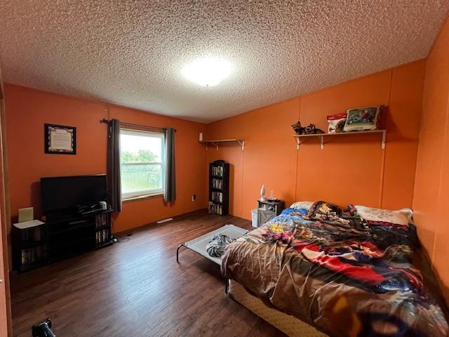 42626 County Highway 125, Perham Twp, MN 56573 - bedroom with a textured ceiling and wood finished floors