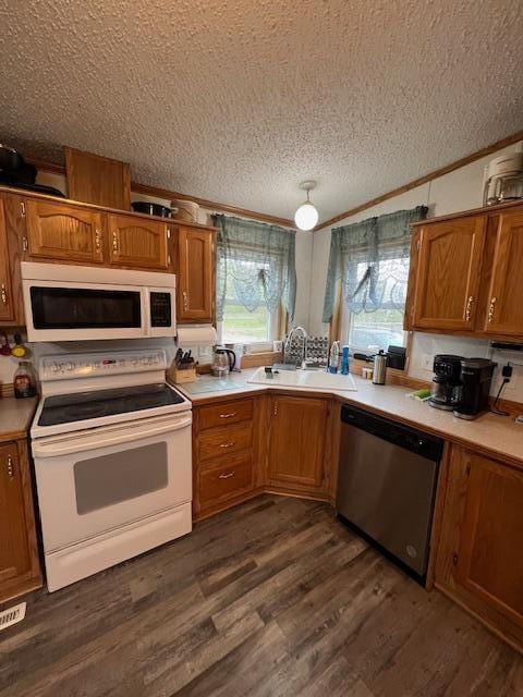 42626 County Highway 125, Perham Twp, MN 56573 - kitchen featuring white appliances, a textured ceiling, a sink, light countertops, and crown molding
