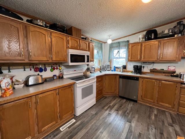 42626 County Highway 125, Perham Twp, MN 56573 - kitchen featuring white appliances, a textured ceiling, brown cabinets, dark wood-type flooring, and light countertops