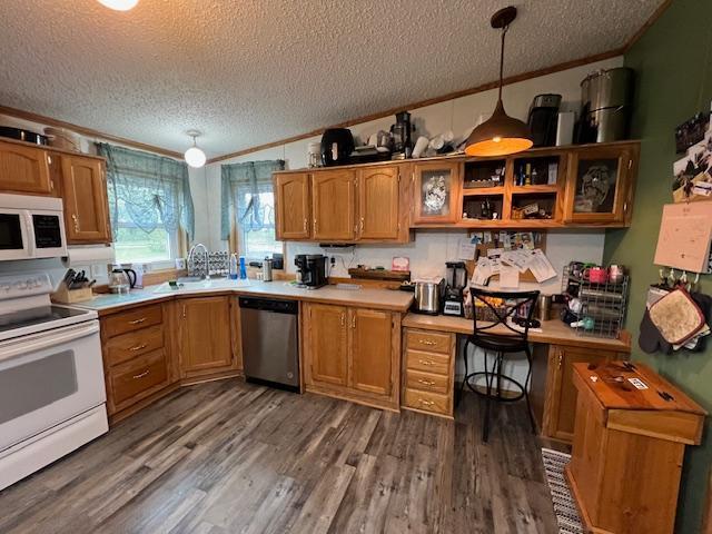 42626 County Highway 125, Perham Twp, MN 56573 - kitchen with white appliances, ornamental molding, a textured ceiling, a sink, and brown cabinets