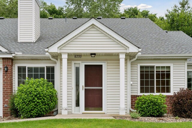 8733 Baxter Way Unit 47, Inver Grove Heights, MN 55076 - view of exterior entry featuring roof with shingles, brick siding, and a chimney