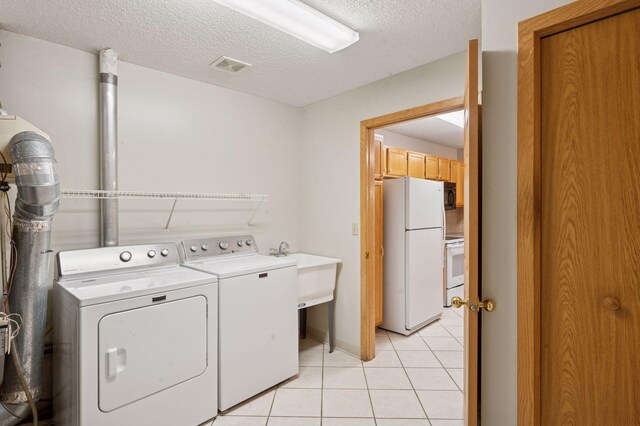 8733 Baxter Way Unit 47, Inver Grove Heights, MN 55076 - washroom featuring washer and clothes dryer, light tile patterned floors, and a textured ceiling