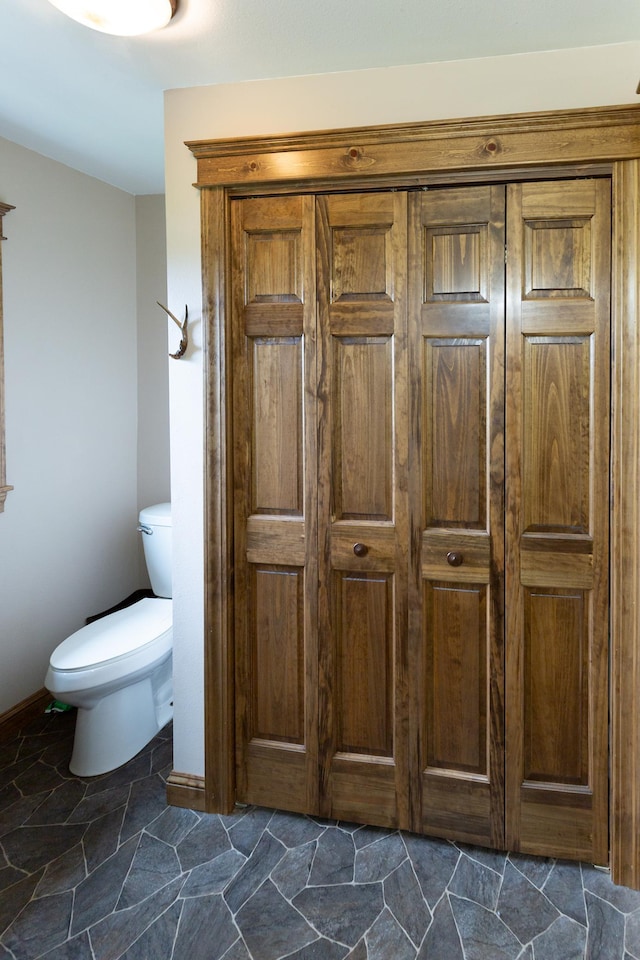 642 4th St, Turtle Lake, WI 54004 - bathroom featuring toilet, baseboards, and stone finish floors