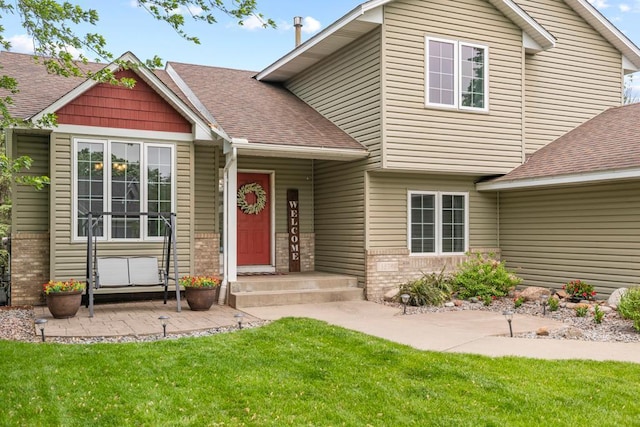 1279 146th Ln NW, Andover, MN 55304 - view of front of house featuring a front lawn, brick siding, roof with shingles, and a patio