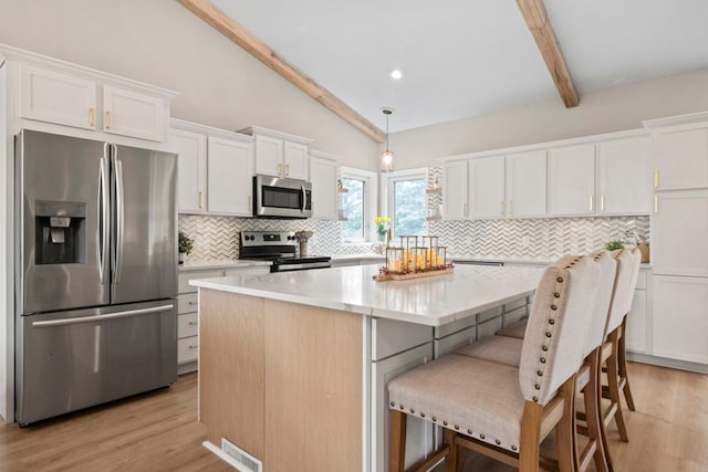 1279 146th Ln NW, Andover, MN 55304 - kitchen with stainless steel appliances, tasteful backsplash, white cabinetry, a center island, and light wood finished floors