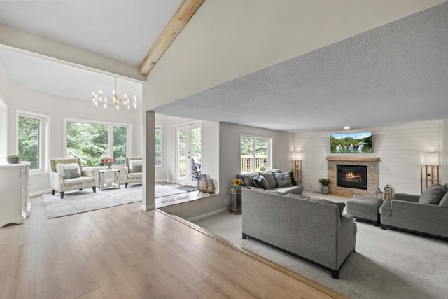 1279 146th Ln NW, Andover, MN 55304 - living area featuring baseboards, a chandelier, a fireplace, wood finished floors, and beamed ceiling