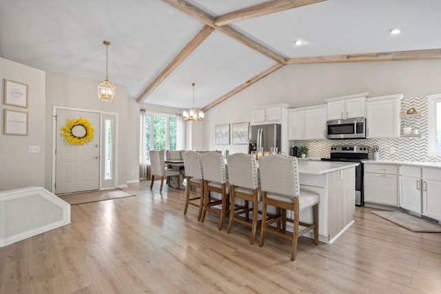 1279 146th Ln NW, Andover, MN 55304 - kitchen featuring appliances with stainless steel finishes, a chandelier, a kitchen island with sink, a breakfast bar area, and backsplash