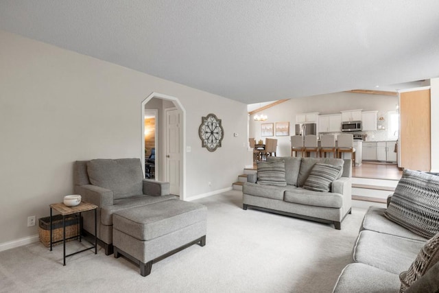1279 146th Ln NW, Andover, MN 55304 - living room with arched walkways, light carpet, baseboards, and a chandelier