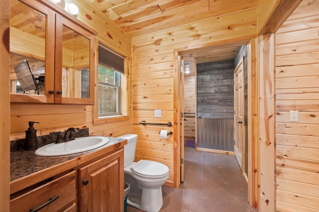 52852 Brush Shanty Lake Rd, Bigfork, MN 56628 - bathroom featuring toilet, vanity, wooden walls, finished concrete flooring, and wood ceiling