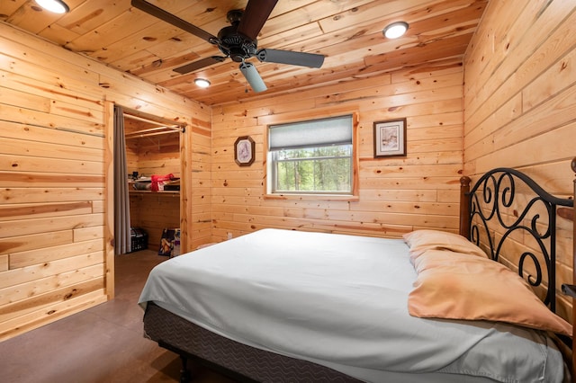 52852 Brush Shanty Lake Rd, Bigfork, MN 56628 - bedroom featuring wood walls, wood ceiling, finished concrete floors, and a walk in closet