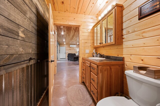 52852 Brush Shanty Lake Rd, Bigfork, MN 56628 - half bathroom featuring finished concrete floors, wooden walls, toilet, vanity, and wood ceiling