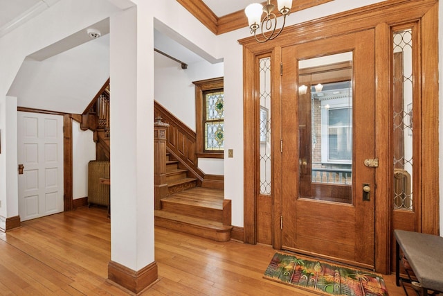 776 Summit Ave, Saint Paul, MN 55105 - foyer featuring light wood finished floors, stairway, ornamental molding, and a chandelier