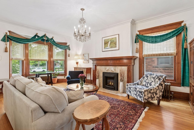 776 Summit Ave, Saint Paul, MN 55105 - living area featuring ornamental molding, a chandelier, light wood finished floors, a high end fireplace, and radiator heating unit