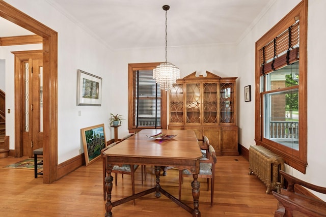 776 Summit Ave, Saint Paul, MN 55105 - dining space featuring radiator heating unit, light wood finished floors, a chandelier, and ornamental molding
