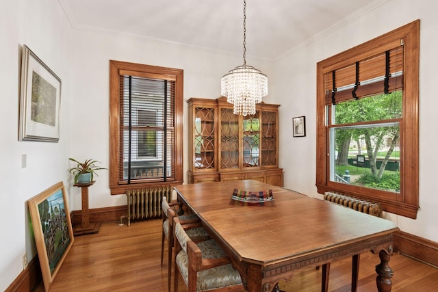 776 Summit Ave, Saint Paul, MN 55105 - dining room with radiator heating unit, wood finished floors, a chandelier, and ornamental molding