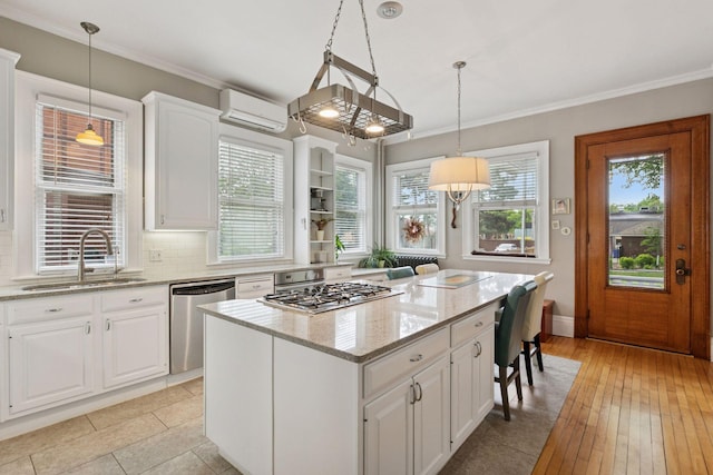 776 Summit Ave, Saint Paul, MN 55105 - kitchen with appliances with stainless steel finishes, a wall unit AC, a center island, light stone counters, and white cabinets