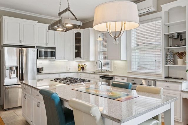 776 Summit Ave, Saint Paul, MN 55105 - kitchen with appliances with stainless steel finishes, crown molding, a center island, white cabinets, and decorative backsplash