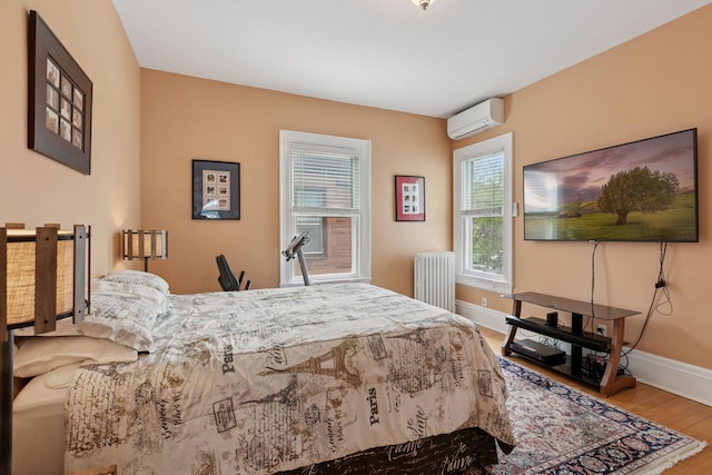 776 Summit Ave, Saint Paul, MN 55105 - bedroom with radiator heating unit, an AC wall unit, and wood finished floors