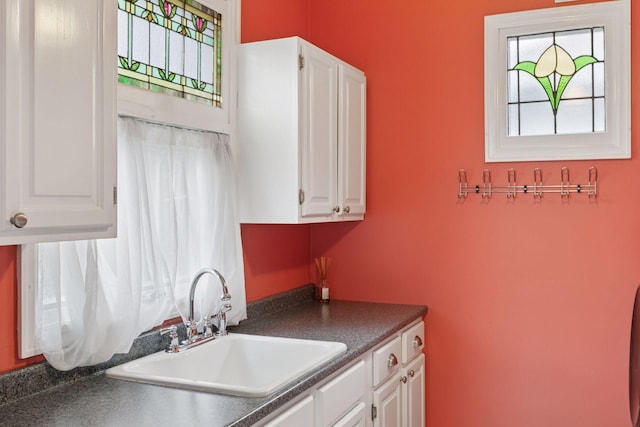 776 Summit Ave, Saint Paul, MN 55105 - kitchen with healthy amount of natural light, dark countertops, and white cabinetry