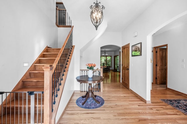 6415 Queensland Ln N, Maple Grove, MN 55311 - foyer entrance with a chandelier, arched walkways, wood finished floors, and stairs