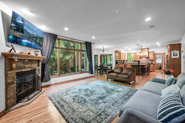 6415 Queensland Ln N, Maple Grove, MN 55311 - living room featuring a chandelier, recessed lighting, light wood finished floors, a fireplace, and baseboards