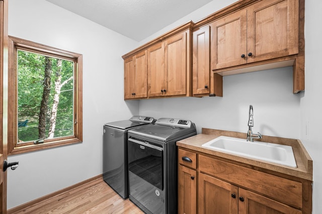 6415 Queensland Ln N, Maple Grove, MN 55311 - laundry room with washing machine and clothes dryer, cabinet space, and light wood-type flooring