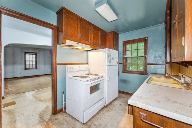 3032 County Road H2, Mounds View, MN 55112 - kitchen featuring white appliances, under cabinet range hood, a sink, light countertops, and baseboards