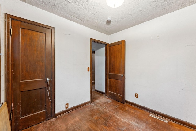 3032 County Road H2, Mounds View, MN 55112 - unfurnished room with wood finished floors, baseboards, and a textured ceiling