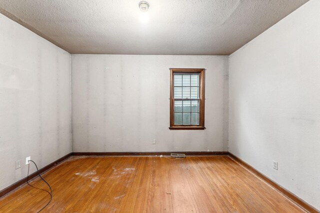 3032 County Road H2, Mounds View, MN 55112 - empty room with hardwood / wood-style flooring, baseboards, a smoke detector, and a textured ceiling