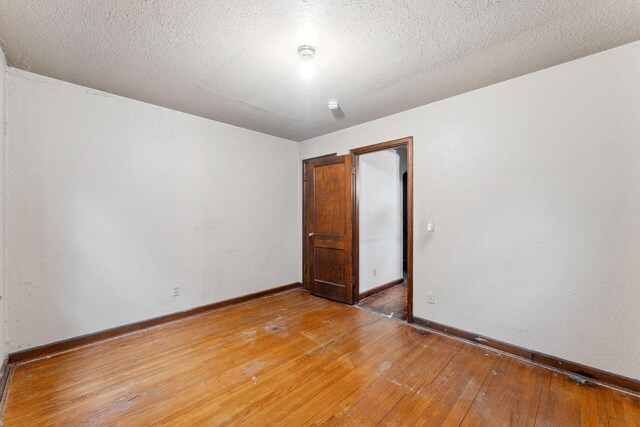 3032 County Road H2, Mounds View, MN 55112 - spare room with light wood finished floors, baseboards, and a textured ceiling