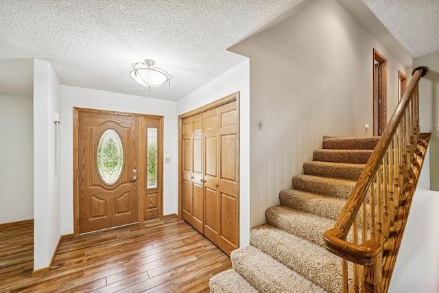 2216 146th Ave NE, Ham Lake, MN 55304 - entrance foyer with a textured ceiling, stairway, and light wood-style flooring