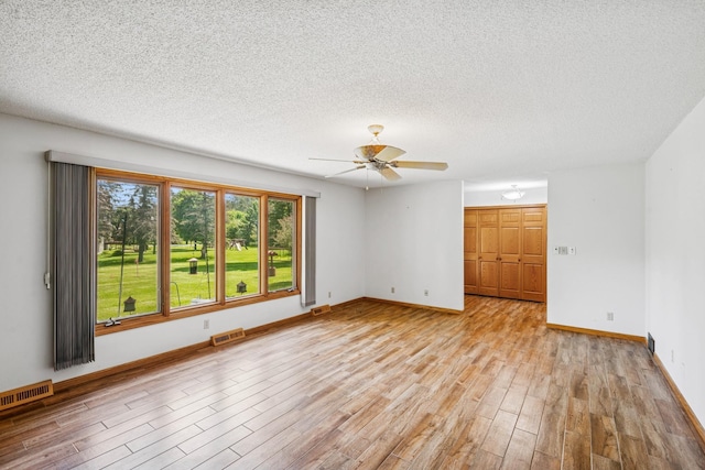 2216 146th Ave NE, Ham Lake, MN 55304 - spare room featuring light wood-style flooring, a ceiling fan, and a textured ceiling