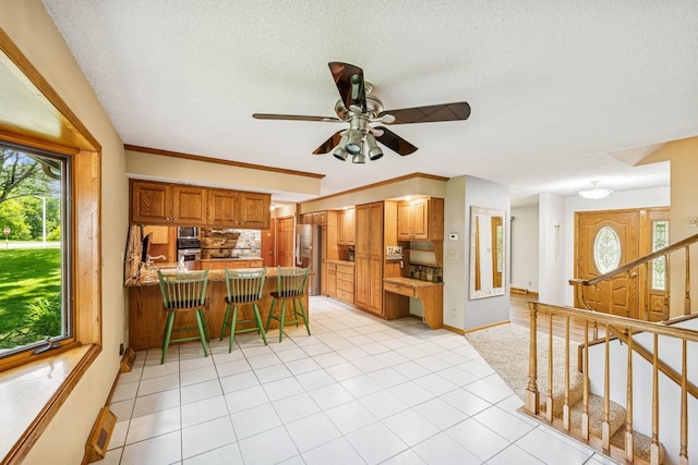2216 146th Ave NE, Ham Lake, MN 55304 - kitchen featuring stainless steel appliances, a peninsula, backsplash, light tile patterned floors, and a textured ceiling